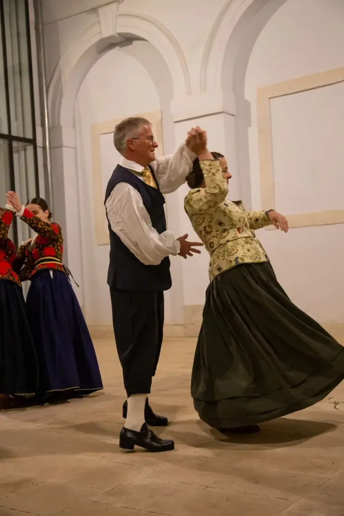 Plesač i plesačica u okretu; tamnozelena suknja raširila se u plesu.